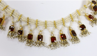 An Indian yellow metal mounted triple strand seed pearl and graduated twenty stone garnet set drop fringe necklace, 40cm.